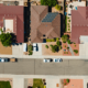 Overhead view of a neighborhood of houses facing a residential street with cars parked on it