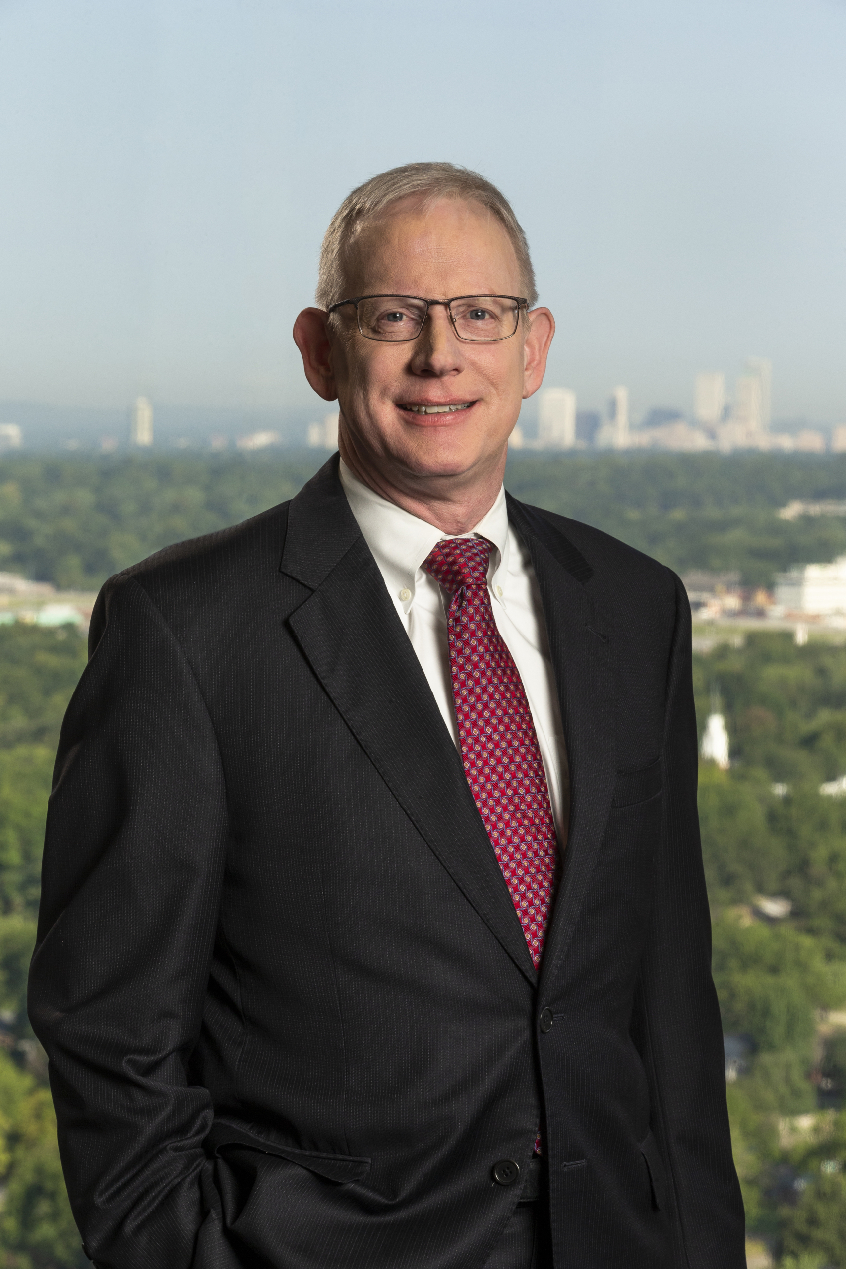 Bob McCormick stands with the skyline of downtown Tulsa behind him