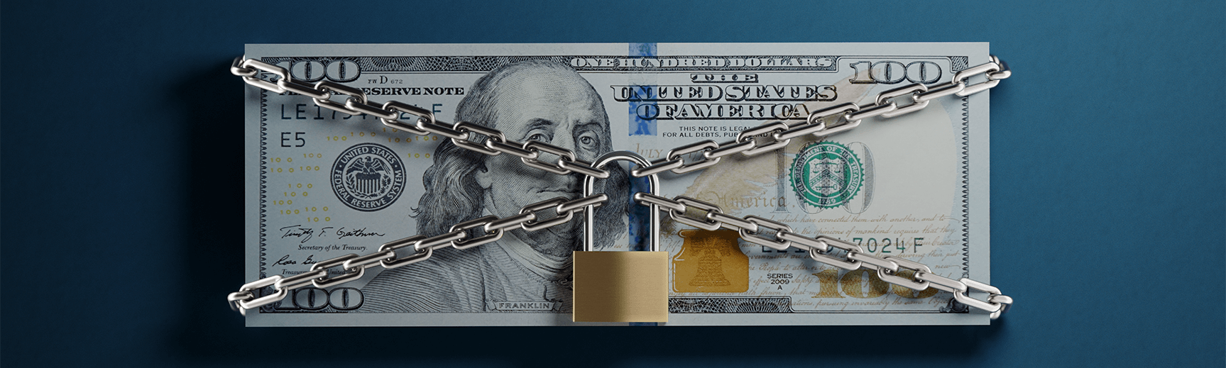 A stack of 100 dollar bills are covered by chains and a padlock